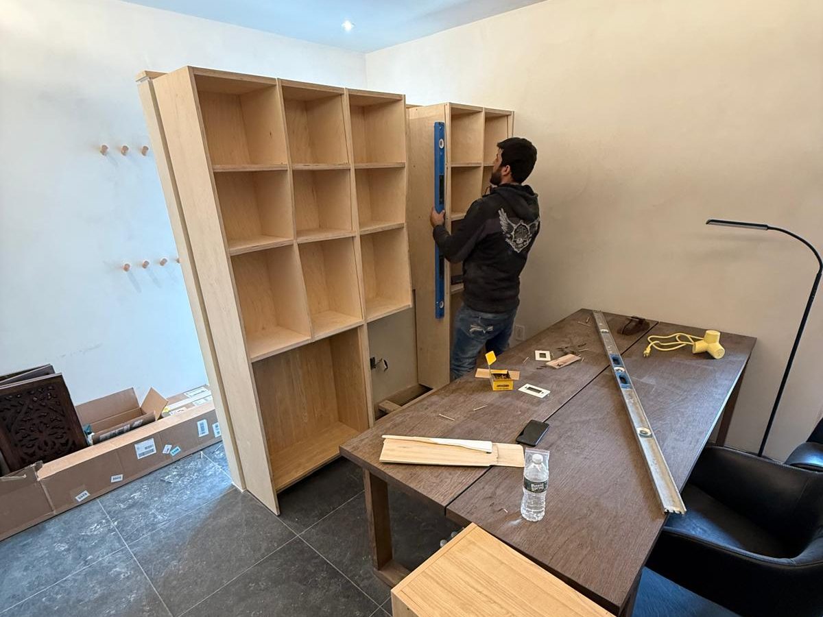 AP Tile carpenter checking a built-in bookcase for plumb with a level