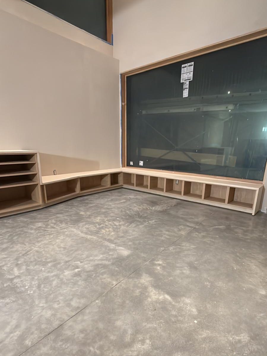 Built-in cubbies and bench wrapping the corner below the basement window