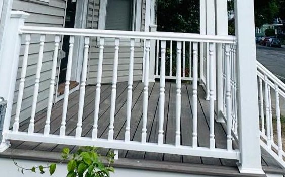 Composite porch decking framed by white turned balusters