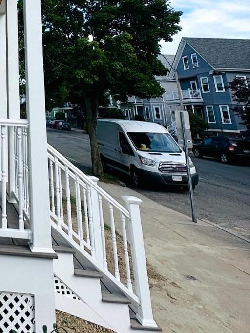 Porch stairs with white railings leading down to the sidewalk