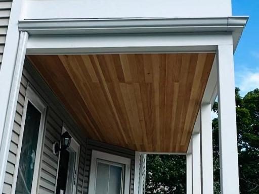 Tongue-and-groove wood porch ceiling under the upper balcony