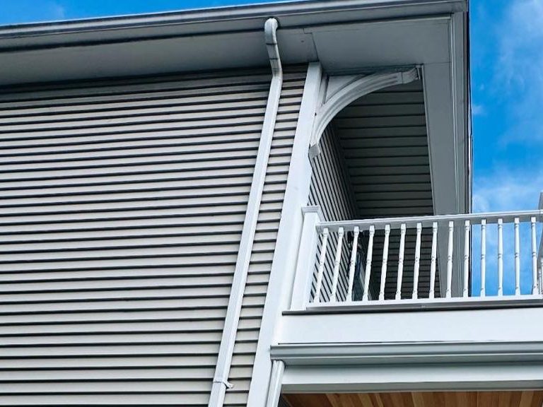 Vinyl lap siding, gutter and decorative eave bracket on the porch corner