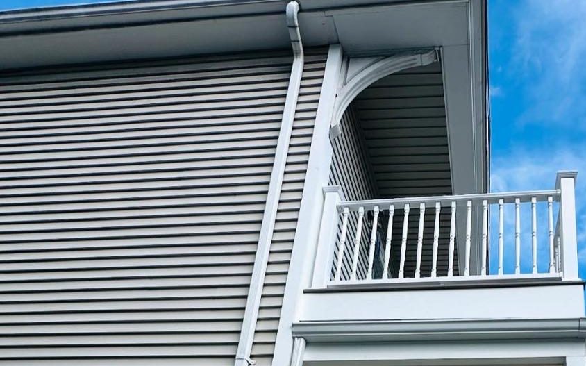 Vinyl lap siding, gutter and decorative eave bracket on the porch corner