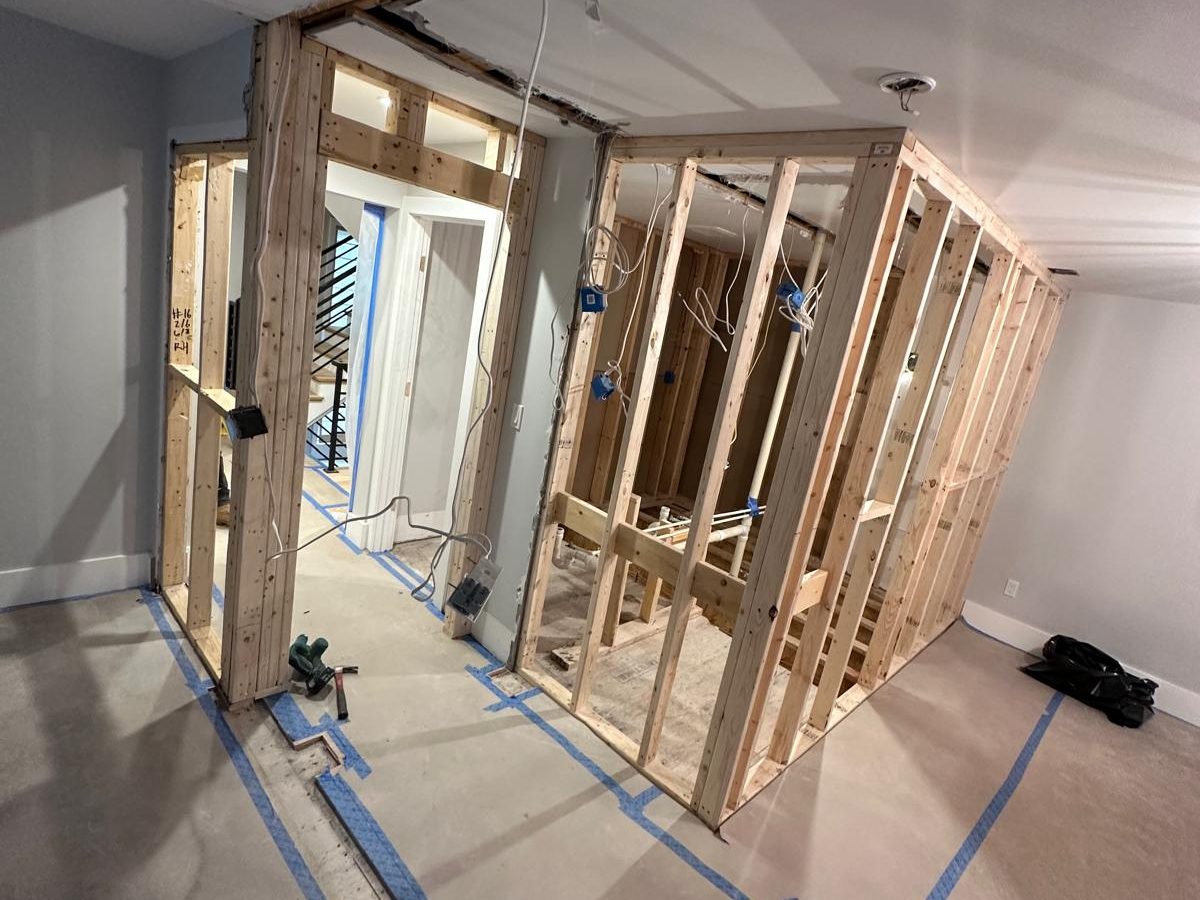 New interior walls framed in lumber with a header over the doorway and rough electrical boxes