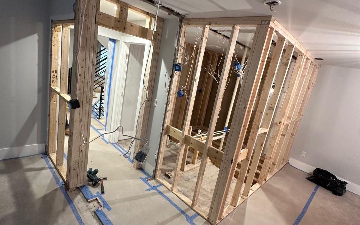 New interior walls framed in lumber with a header over the doorway and rough electrical boxes