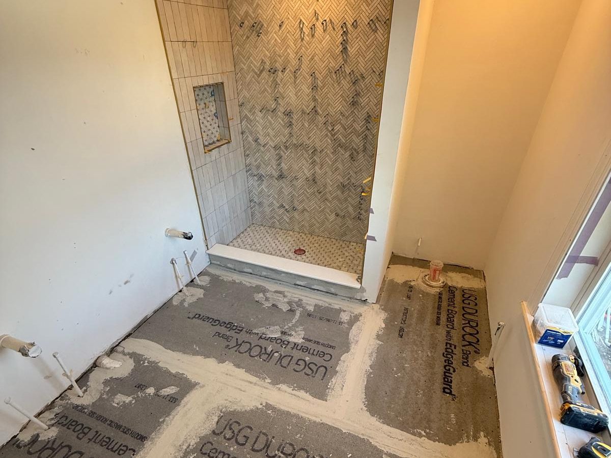 Finished shower tile while the bathroom floor is still bare cement backer board