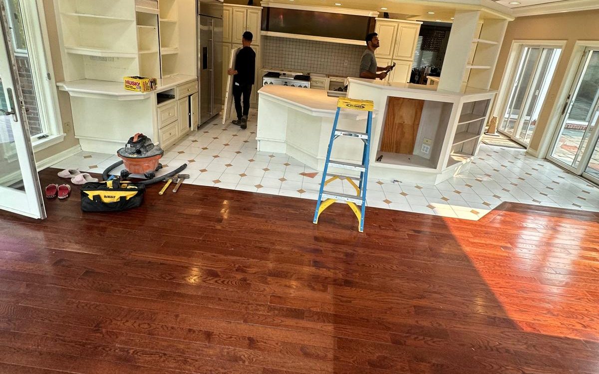 Kitchen before the remodel: white cabinets, white tile with brown accents and a cherry hardwood floor