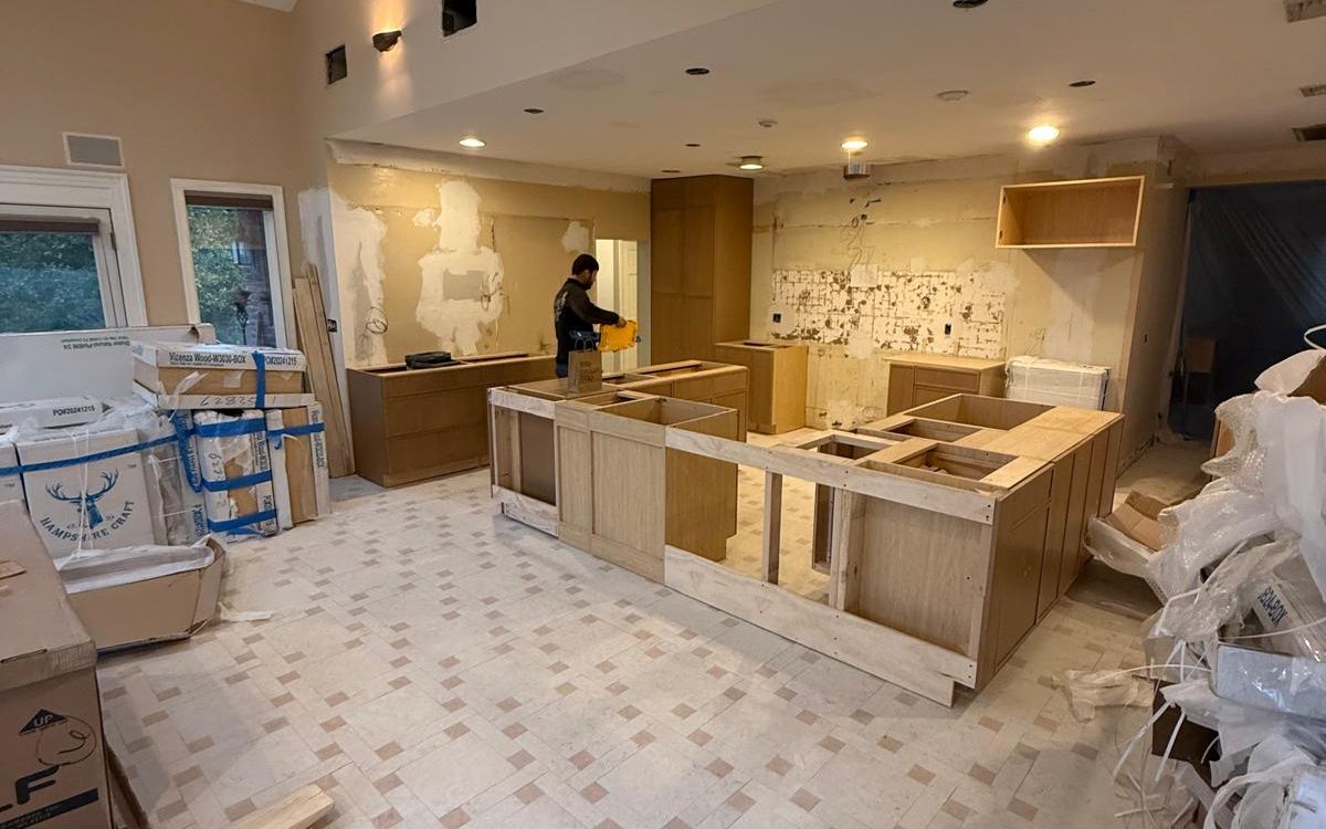 New wood cabinets being installed on the finished tile floor