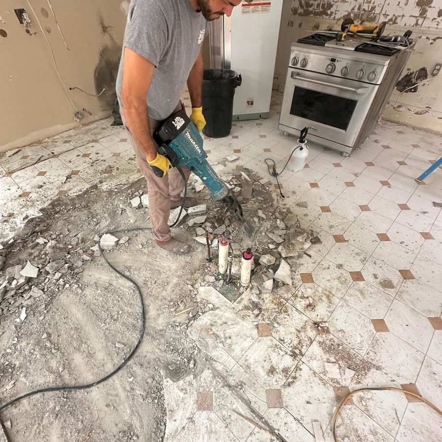 Breaking out the old tile and slab with a demolition hammer