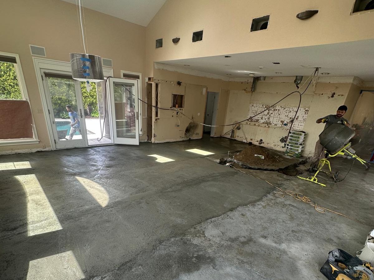 Freshly screeded floor across the open kitchen and family room, with patio doors along the back