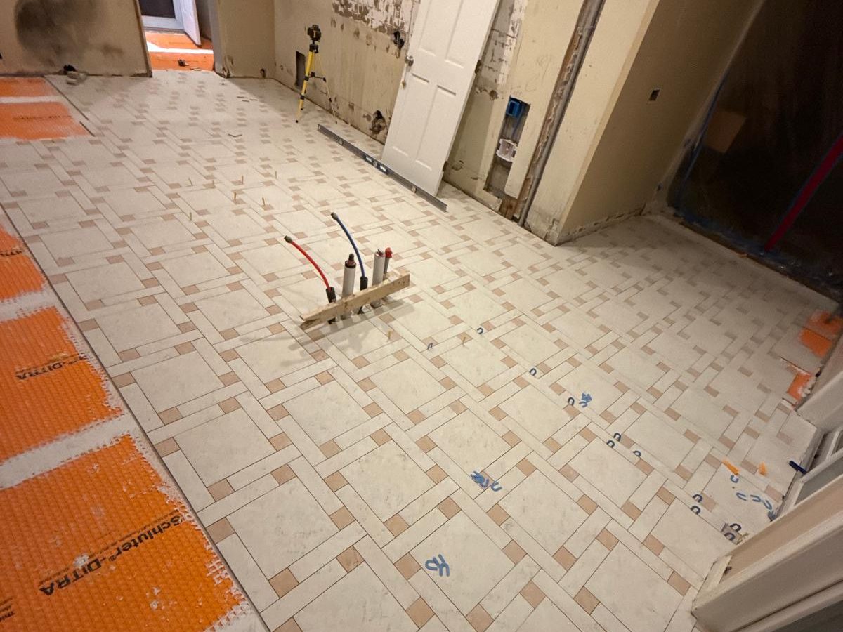 Woven pattern of large porcelain squares and small accent tiles set over the membrane
