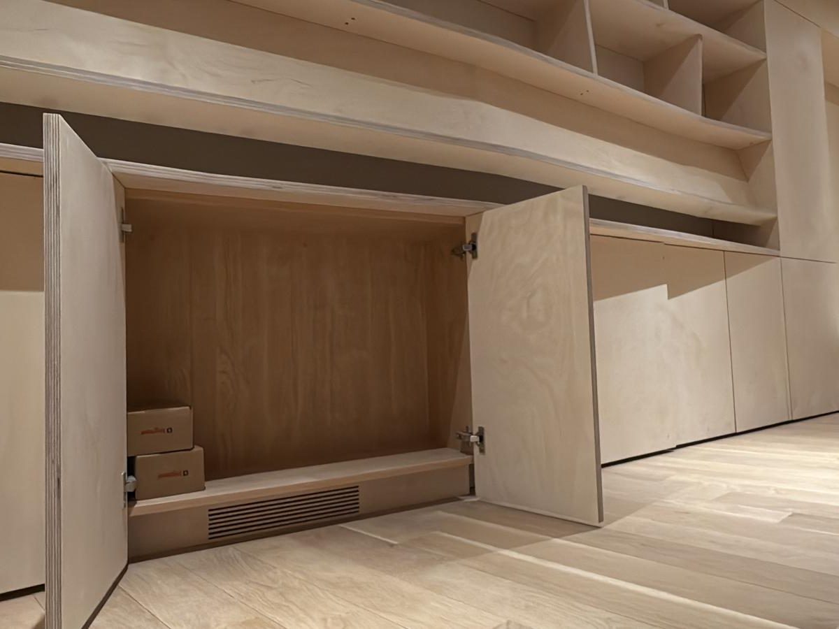Open cabinet door revealing a vent integrated inside the built-in