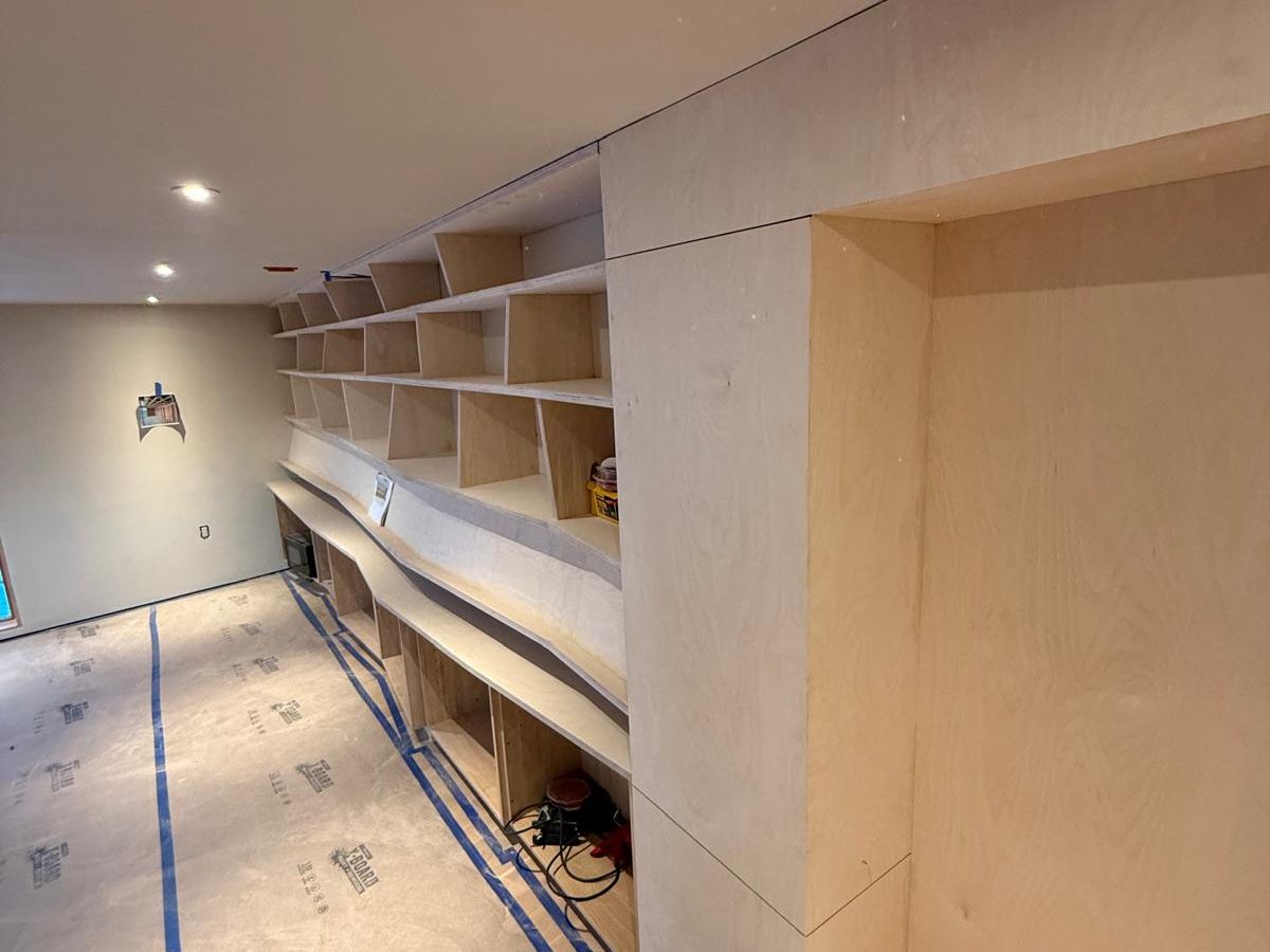 Built-in shelves and an alcove bench during installation, floor protected