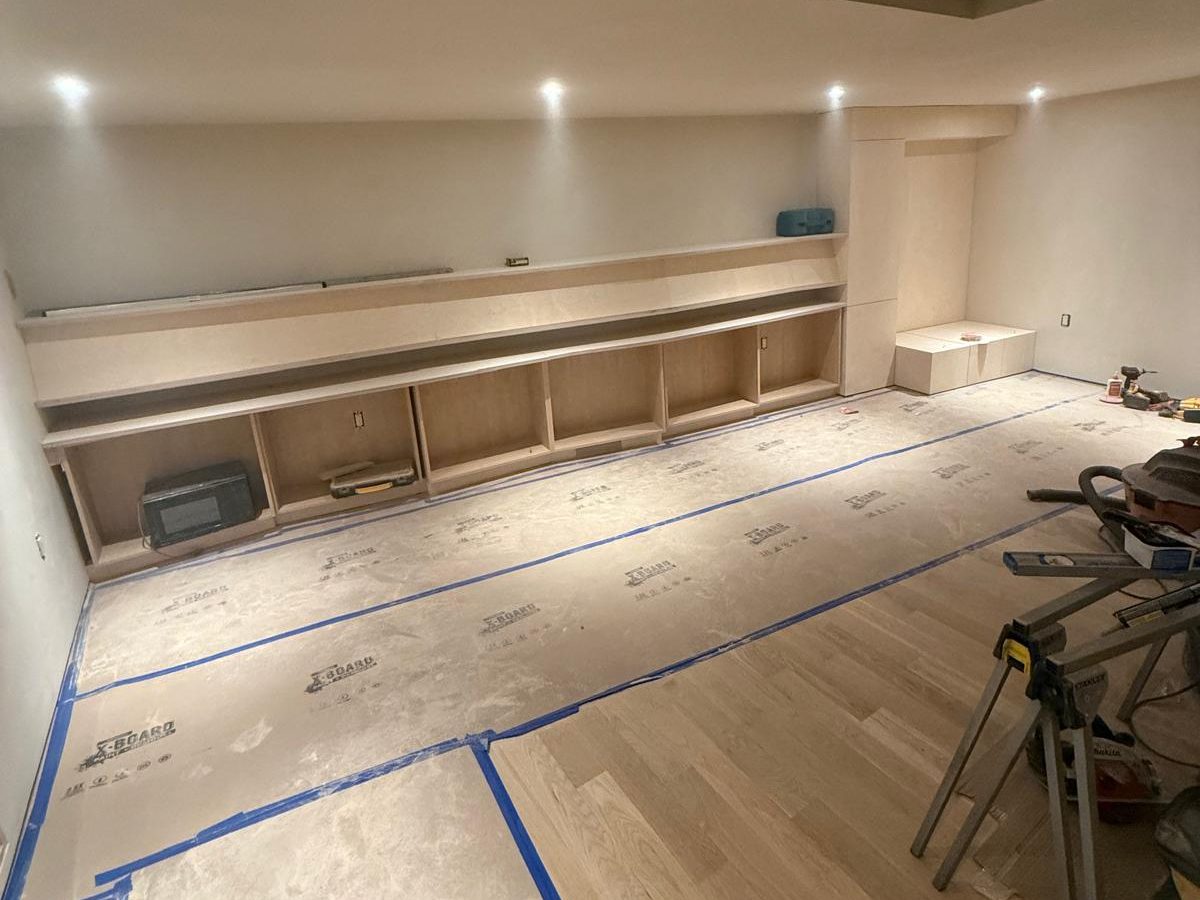 Base cabinets and long shelves going in along a freshly painted wall