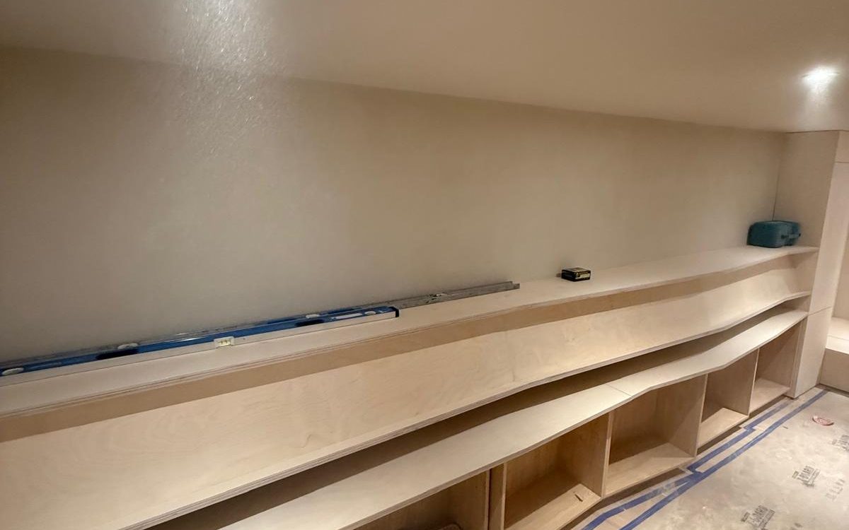 Base cabinet boxes and floating shelves set level along the wall