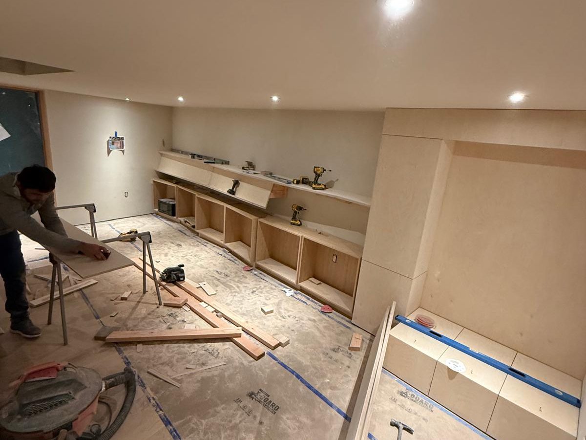 Carpenter cutting parts on site while the library cabinets take shape