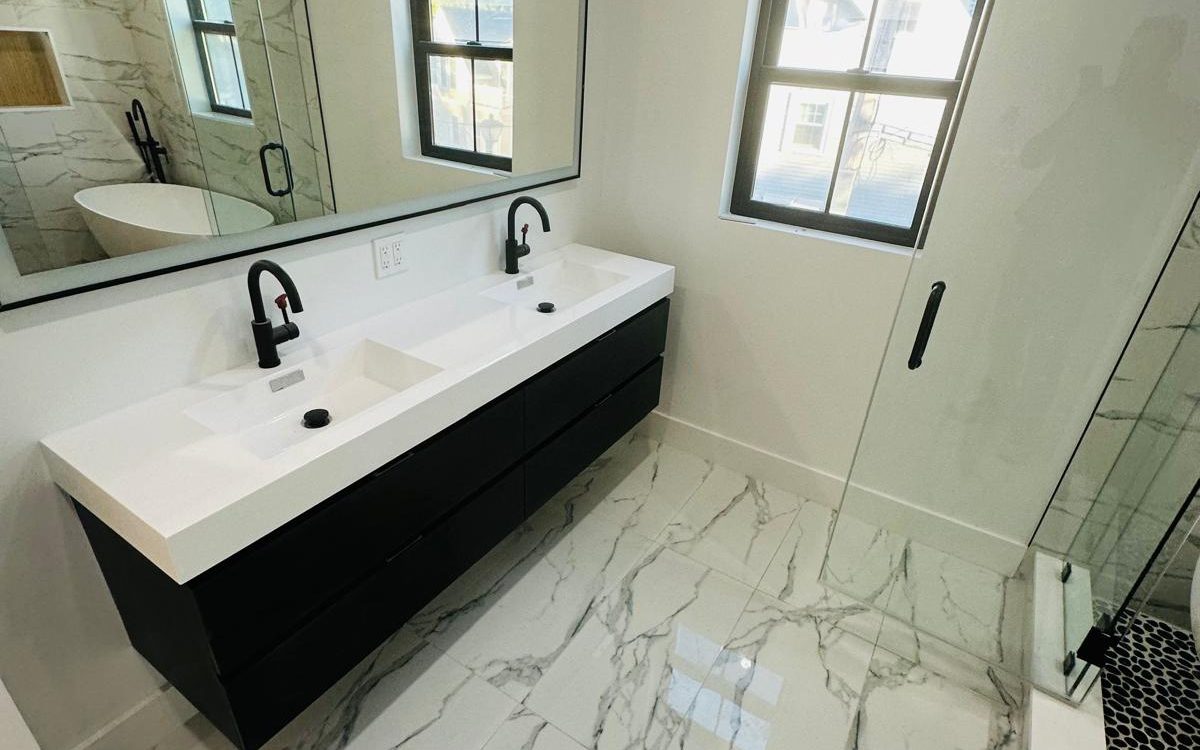 Floating black double vanity with a white top on large-format marble-look porcelain