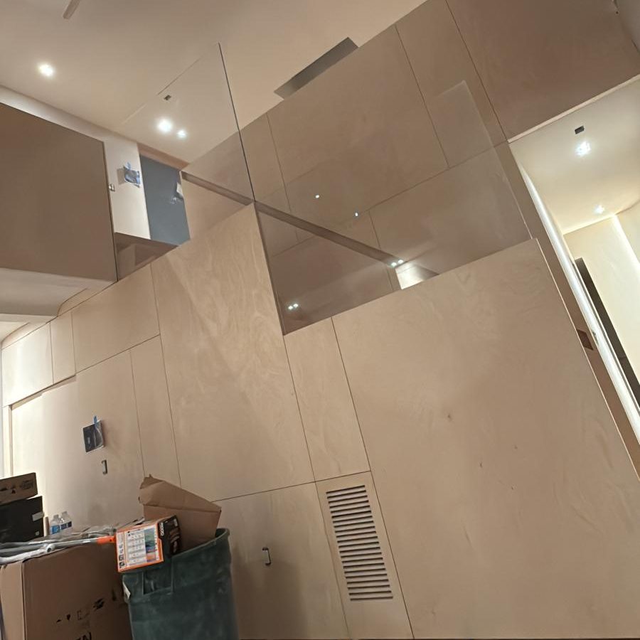 Birch plywood stair wall with a frameless glass guard and a flush vent