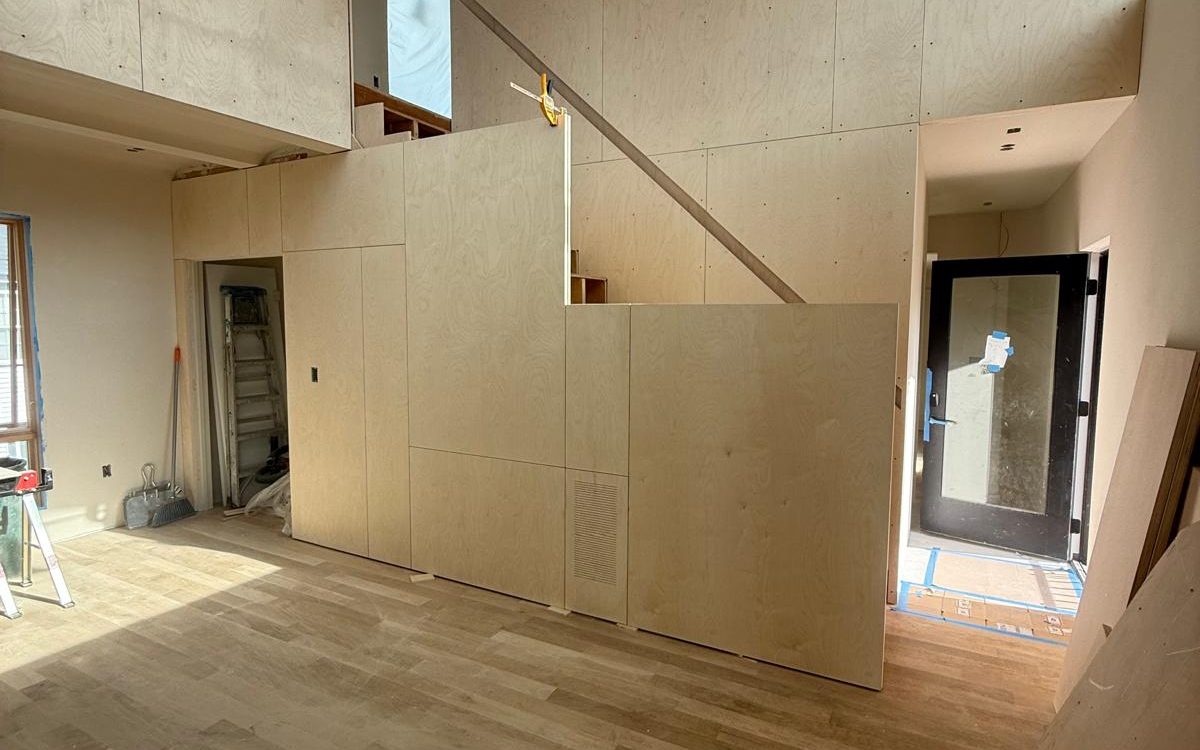 Birch plywood wall panels with a flush vent beside the new oak floor