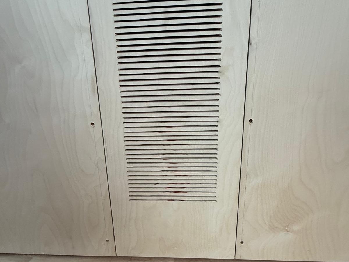 Close-up of a slotted ventilation panel cut into birch plywood