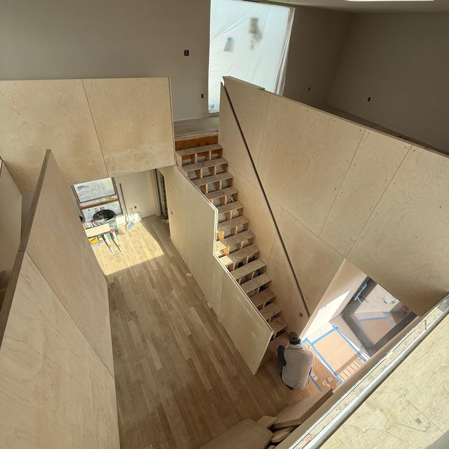 Looking down the panel-wrapped stair to the new oak floor below