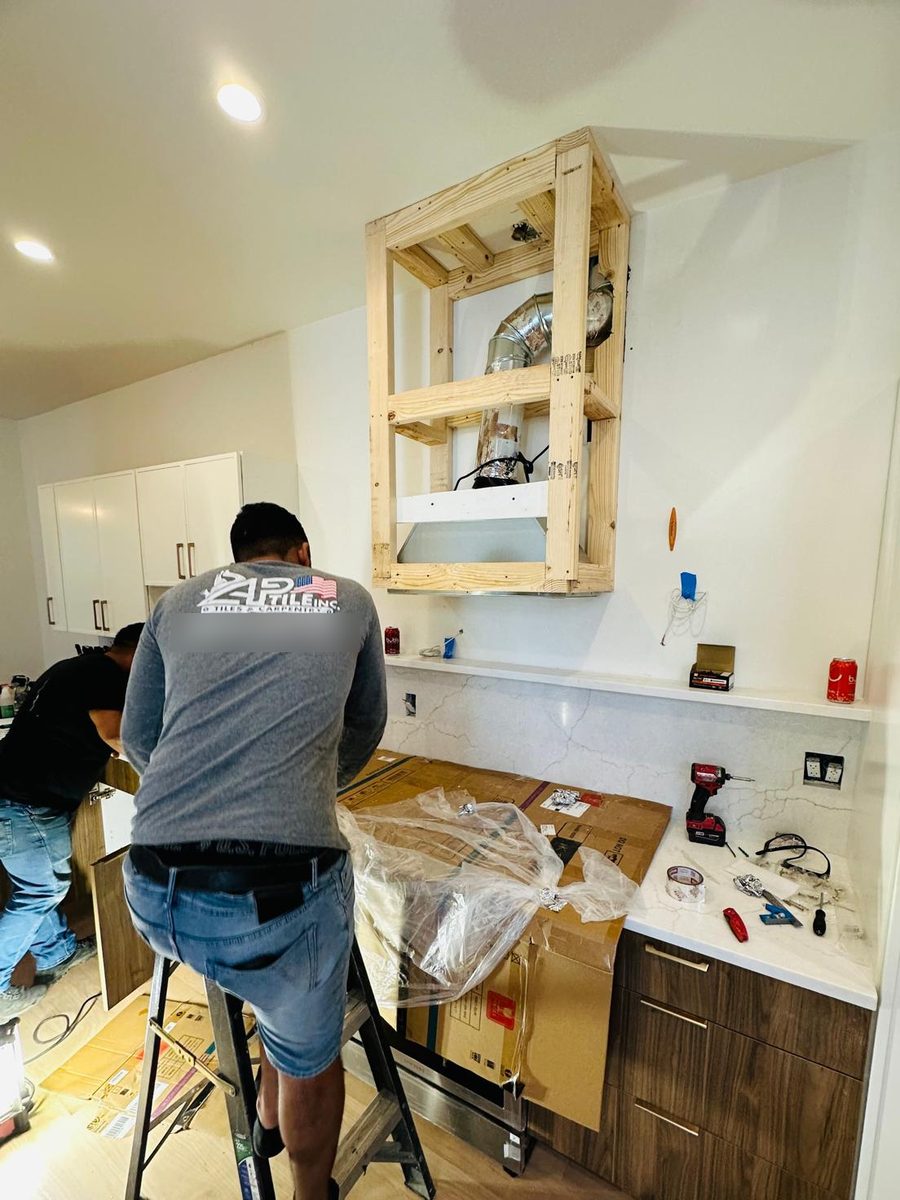 AP Tile crew framing the range hood enclosure above the quartz counter